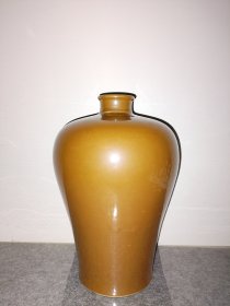 康熙紫金釉大梅瓶，玉璧底，糯米胎，高约30CM，造型大气，瓶肩上耸。名贵紫金色，独特稀少。有鼓包、缩釉点、火石红老瓷痕迹。脱口垂足，十倍镜下可见橘皮纹，是进一步断代特征。瓶底糯米胎整洁细腻。玉壁底见手工螺旋纹及火石红和黑斑，瓶内壁见拉坯纹和接胎痕。整体器物雍容华贵，世所罕见。