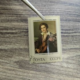 这是一张苏联邮票，邮票上印有“ГОСУДАРСТВЕННАЯ ТРЕТЬЯКОВСКАЯ ГАЛЕРЕЯ - МОСКВА”（意为“国家特列季亚科夫美术馆 - 莫斯科”），人物下方署名“В.А. ТROPИНИН” ，代表画家瓦西里·安德烈耶维奇·特罗皮宁。邮票面值为2戈比，发行于1973年。特罗皮宁是俄罗斯著名的肖像画家，以描绘普通民众的日常生活和形象著称。