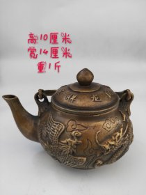 旧藏:【龙凤纹提梁铜壶】 尺寸：高10cm壶宽14cm重1斤。 这款铜壶为圆形盖口，壶盖浮雕龙凤呈祥字体，圆腹，整体雕刻纹路精湛，腹部主题绘制龙凤纹，凤首高昂，凤尾卷起，云龙畅游，龙凤嬉戏场景描绘精准生动，纹路清晰可见，更显霸气。匠师巧妙地设计布局，生动准确的刻划，使画面栩栩如生。底部刻有款式。整体以精铜制作，铜质细腻，铸造精工，发出淡淡的光泽，让人爱不释手。收藏佳品！