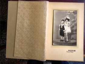 民国时期二位穿着西式裙子和服装的小朋友合影，蝶求照相馆。