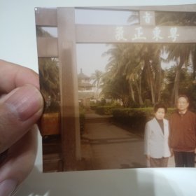老照片–夫妻二人在海南景区留影（1997年1月，身后有“粤东正气”四个字）