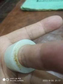 和田玉带沁皮扳指一只，推拔（斜切口）符合人类手指弯曲特性，存于花梨木柜台内