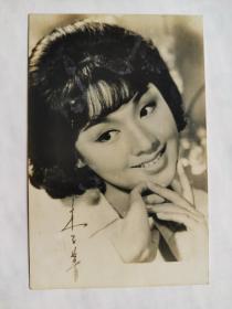 娃娃影后，李菁，美丽微笑照片一张。中国香港电影女演员。李菁1949年随父母移居香港。家中有五个哥哥、两个姊姊，李菁排行最小。自幼就对电影即有兴趣，就读宝血女中时，听闻邵氏所属的“南国实验剧团”公开招收第二期学员，不顾父母反对坚决投考。当年有超过两千人报名应试，李菁凭获清新的外表和表演天份幸运录取，与方盈、江青、郑佩佩、秦萍等四十人成为同期同学。期间，曾客串演出《梁山伯与祝英台》与《玉堂春》