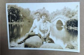 约60年代黑白明信片老照片一张 男女公园留影 背后有桥上有特色文字