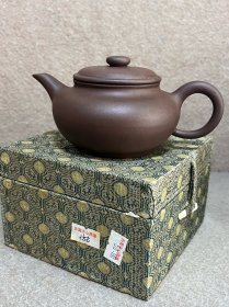 紫砂一厂仿古壶带盒 200 毫升 原矿砂质好，壶流造型佳出水流畅，薄胎鼓腹，窑温高，七十年代的产品，不要与随意说是一厂的紫砂相提并论，保真。 全美品。