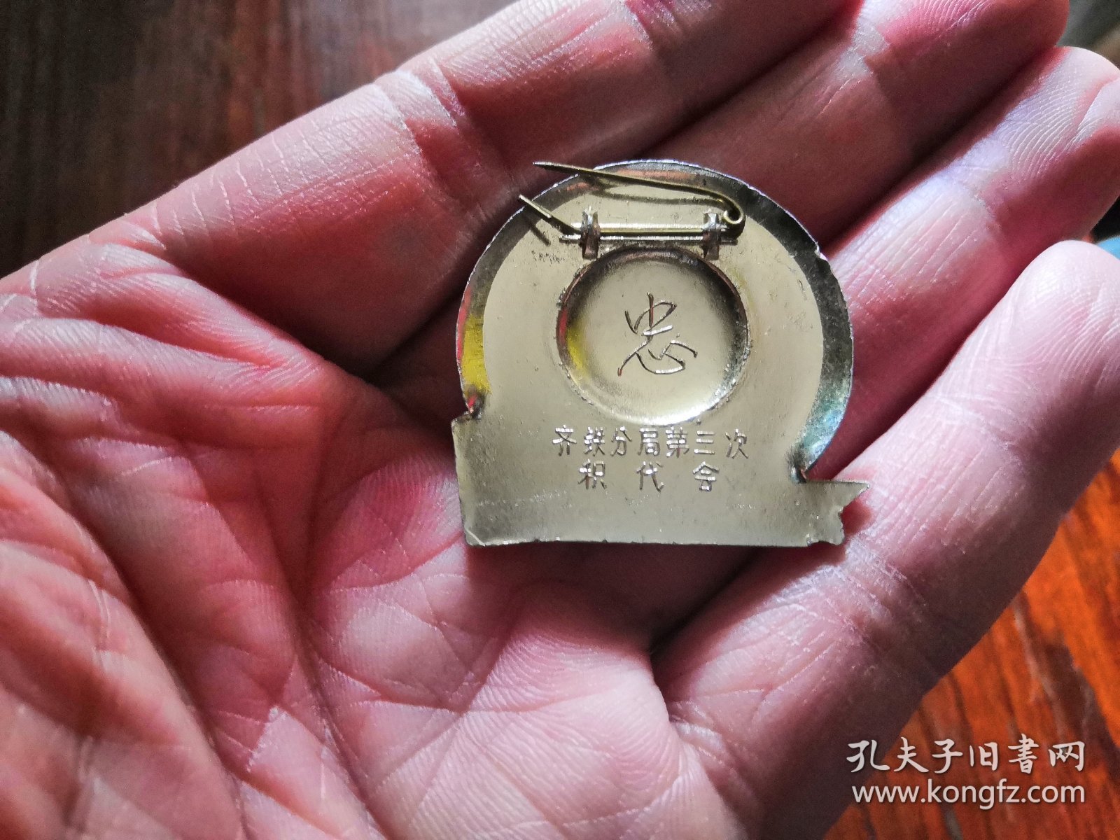 齐铁分局第三次积代会异形章，银色头像，深红帽徽漆亮光面，下方为银色舰艇、炮台及《毛泽东选集》组成的图案；背文：忠.齐铁分局第三次积代会。4厘米