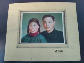 50年代手工上色(夫妻老照片）这是一张人像照片，人物穿着具有特定年代风格的服饰，发型也颇具时代特征，可能拍摄于20世纪中期到晚期。当时的照片常采用这种正式的拍摄方式，背景简洁，人物着装朴素大方，色彩处理上有时会有独特的色调风格 ，这种照片往往承载着那个时代人们的生活记忆与情感。