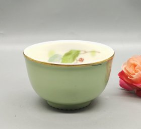 日本君岛由希子大师作品，牛油果绿釉茶杯，内壁手绘绿叶果实图案，金边装饰优雅。杯身光滑细腻，釉色均匀，底部有签名。口沿有一个划痕见图，介意勿拍。口径8厘米，高5厘米。满58包邮偏远地区邮费自付。