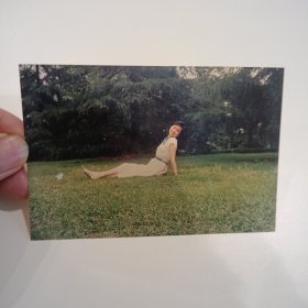 老照片–漂亮女孩坐在景区草坪上留影（穿白色连衣裙）