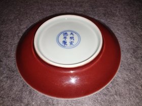 大明宣德宝石红釉盘，红如宝石，宝光四射，胎质青白，胎油莹润。宣德宝石红烧造难度高，后世一直顶礼膜拜而望尘莫及。