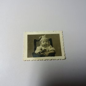 老照片–可爱小孩坐在婴儿椅里吃东西留影（戴帽子）