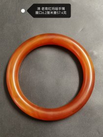 清代 老南红玛瑙手镯，圈口6.2厘米，重57.4克 。色泽如炽热火焰，浓郁且醇厚，在岁月的打磨下，散发着温润而迷人的光泽。南红玛瑙自古便备受珍视，此镯承载着清代的风雅韵味，静静诉说着往昔故事，是古典之美与历史底蕴的完美融合。