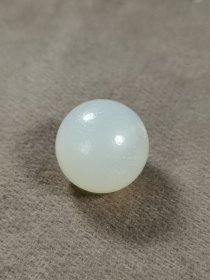 一线收一枚白玛瑙圆珠，风化细腻，光气内敛，奶白皮沁，珠圆质润。规格：直径18.5mm