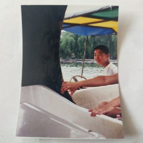 小孩开着游览船在河中留影照片
