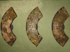 战国至西汉弧形玉璜组，每个约14.5X4cm。 此组三件弧形玉器，为古代组玉佩核心构件，年代拟定为战国中晚期至西汉早期，是研究先秦两汉玉器工艺与贵族礼制的典型实物。 观其形制，三器均为弧形，边缘经精细切割打磨，弧度流畅规整，符合战国至汉代“玉璜”典型造型——玉璜为组佩核心，多弧形，两端或中部穿系，与其他玉饰串联成佩。表面纹饰以勾连云纹为主，线条婉转流畅，填刻细密，属战国玉器“繁缛细腻”风格