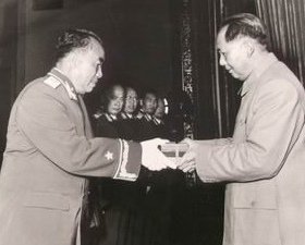 1955年毛泽东给朱总司令授元帅军衔，后面有陈毅，徐向前等等候授衔。新华社七十年代新闻照片
