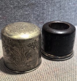 旧藏…老沉香花卉诗文班指带银盒一套 此藏品所取用上等沉香为材料，刀笔有力，运转自如，遇水则沉，沉香味道清香迷人，年久不散，纹理清晰，油性好，皮壳靓，把玩佳品。尺寸3--3.9--2.25公分 重22克 银盒重36克