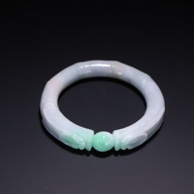 翡翠双龙头竹节手镯，韵味独特。翡翠质地优良，水头尚佳，翠色灵动。双龙头威严霸气，工艺考究，细节处彰显匠心。竹节造型寓意节节高升，为其增添祥瑞内涵。岁月沉淀使其更具古朴质感，是兼具艺术美感与文化意义的珍贵藏品。尺寸 ：内径5.6cm 重69.08克 带鉴定证书