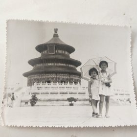 两个小女孩儿打着伞在景区合影留念照片