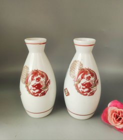 日本九谷烧，龙凤纹酒壶一对，白瓷胎红色龙纹，绿色凤纹。做工精致。手工绘制，金色点缀，工艺精美。底部有九谷款，成色完好，适合实用和收藏把玩。口径3厘米，肚径6厘米，高12厘米。
