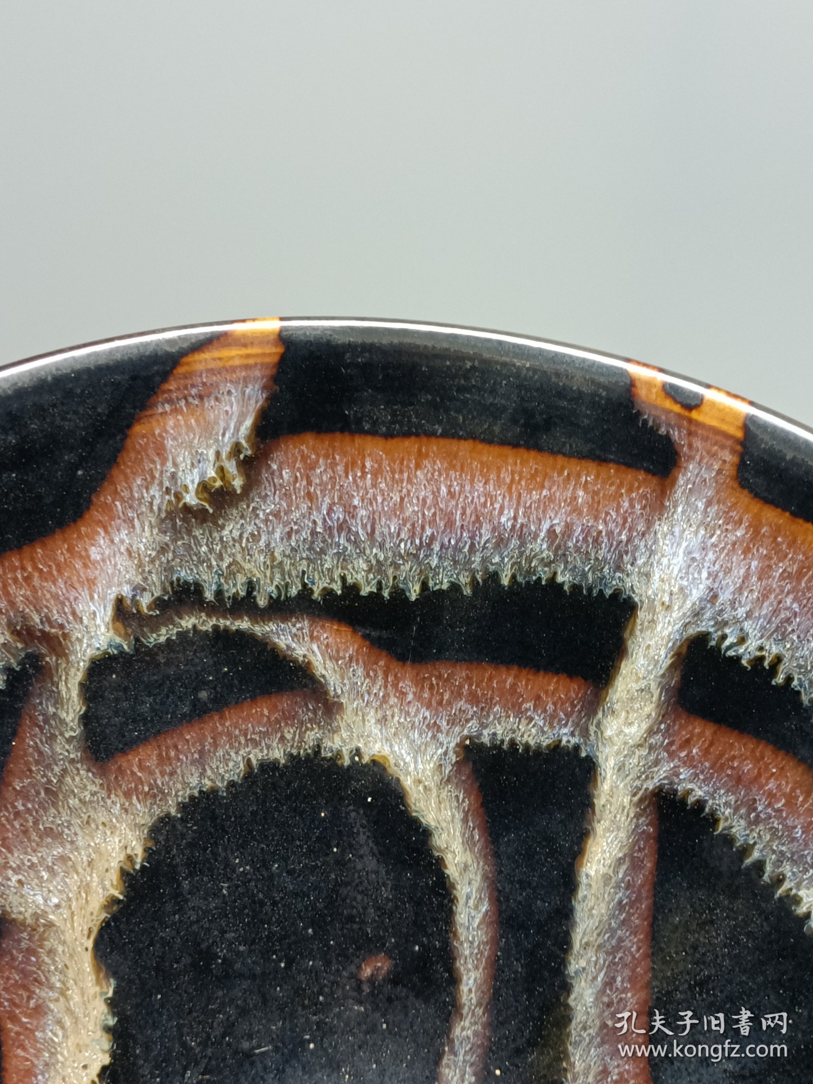 宋代吉州窑洒釉斗笠碗，窑变釉色，黑釉底色配红褐斑纹，釉面自然窑变，线条流畅。碗型规整，胎质细腻，底部干练，整体保存不错，无明显磕碰，品相以图为准。尺寸：直径15.6cm，高5.4cm。适合收藏或茶道使用。