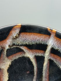 宋代吉州窑洒釉斗笠碗，窑变釉色，黑釉底色配红褐斑纹，釉面自然窑变，线条流畅。碗型规整，胎质细腻，底部干练，整体保存不错，无明显磕碰，品相以图为准。尺寸：直径15.6cm，高5.4cm。适合收藏或茶道使用。