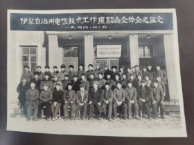 这张照片是“伊犁自治州电信技术工作座谈会全体同志留念” ，拍摄日期为一九六四年一月五日 ，地点是伊犁哈萨克自治州邮电局前。它记录了特定历史时期伊犁地区电信技术工作者的一次会议场景，对研究当时电信行业发展及地方行业工作交流情况有一定参考价值。