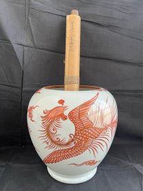 朝阳鸣凤起：民国矾红描金（凤凰舞九天图）大卷缸精品一只：（卷缸）是文房用具，又称“案头缸”、“画缸”，放置卷轴类书画用器。此物平口酱釉，颈周云纹，鼓腹下渐收，圈足。细密胎质、丰腴莹润釉水反映出当时优质原料选择和成熟制胎工艺。其以矾红描金形成鲜明对比基调，精绘凤凰展翅飞翔，羽翼飘逸，如在云端起舞，气势非凡，寓意吉祥。凤兮凤兮，百鸟之王。巢于阿阁，鸣于高岗。世有圣人，载飞载扬。我仪图之，兆兹嘉祥。