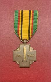 比利时二战胜利纪念奖章
此奖章是根据1967年12月19日皇家法令设立的比利时战争奖章，颁发给第二次世界大战期间从英格兰参加战斗的所有比利时武装部队成员。
奖章为铜质，做工精细，奖章正面图案：十字架背后有一圆形，十字架中心是一把垂直向上的宝剑，两侧写有年份“1940-1945”；背面十字架中心为比利时狮。挂布带有金属别针，品相很好。