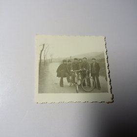 老照片–六名青年在乡村路中间留影（身旁两辆自行车，周围树木和山坡清晰可见）