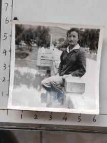 50-60年代粗辫子美女坐在石围栏上照片(邹位相册，邹位约1961年毕业于昆工附中，之后就读于昆明工学院)