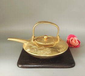日本镀金茶壶，松竹梅龟鹤纹饰，做工精致漂亮。壶身锤目纹理，壶身有精美的浮雕图案。全新品相，适合收藏或使用。长15.5厘米，宽12厘米，高5.5厘米。不包括实木托盘。