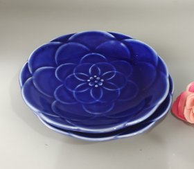两片深蓝色花朵陶瓷碟，精美浮雕花瓣设计，釉色漂亮，做工精致。尺寸合适做茶点、果盘，全新未使用。底部有品牌标记，适合下午茶、甜点摆放。直径13.5厘米，高2.5厘米。满58包邮偏远地区邮费自付。