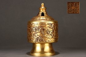 年代自鉴，精美鎏金器千鹤纹筒式熏炉 高18cm 口径8.8cm 重5斤，宣德款 该器作圆筒式，平口，筒腹，下呈高圈足，敦实沉稳。腹部云纹锦地，通景浮雕精作千鹤纹，鎏金装饰，泽光熠熠，雍容典雅。整器制范规整严谨，敦厚之中不失灵巧精致，是为书房陈设雅器。