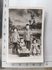 四小朋友合影照片(其中站立二小朋友佩戴红小兵袖套，另外一小朋友坐小汽车)