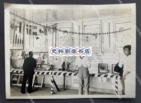 【长春史料】1935-1937年间 伪满洲国新京“关东局保健所”举办的“健康展览会”会场内关于“沙眼”的宣传墙 原版老照片一张（宣传墙挂满图文并茂的宣传画，展柜上有器官模型等展品，会场内悬挂有“万国旗”。关东局保健所旧址位于长春人民大街与珠江路交会处东北角，建于1910年，初时为警察署官邸，1935年由日本关东局设为中央通保健所，1937年改称“新京特别市中央保健所”。）