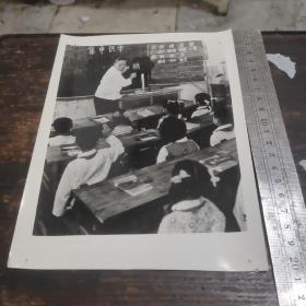 老照片，老师在教室里教学生认字。