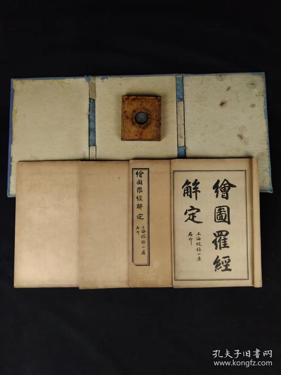 清代晚期《罗经解定》全套四册+方形罗盘一件，罗经，也叫罗盘，是一门博大精深的学问，揭示“天人合一”，形成一套百科荟萃的理论，将人的生死祸福，吉凶休咎与天地万物紧密地联系在一起，把天，地，人三才尽纳罗经之中。经即经天纬地之意，罗盘为风水术的唯一正式工具，是将理，气，形，数系统结合在一起而制成的一种时空合一的风水器具。是具体阐述这一风水器具的最权威性著作。单页尺寸20/13厘米！