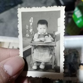 1970年儿童坐在小孩椅子上，周岁小影老照片