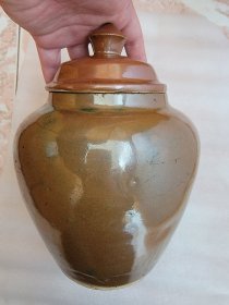 清代，紫金釉盖罐一件，罐体内外施釉，罐足心处有老货标志性小奶突，高约21.6厘米。