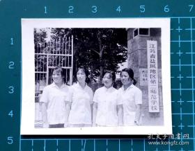 老照片：七八十年代女学生在“江苏省盐城地区第二师范学校即阜宁师范门口合影黑白照片，品相如图，长6厘米，宽4.8厘米