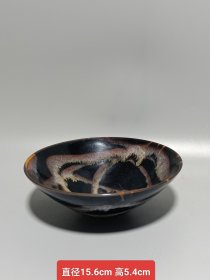 宋代吉州窑洒釉斗笠碗，窑变釉色，黑釉底色配红褐斑纹，釉面自然窑变，线条流畅。碗型规整，胎质细腻，底部干练，整体保存不错，无明显磕碰，品相以图为准。尺寸：直径15.6cm，高5.4cm。适合收藏或茶道使用。