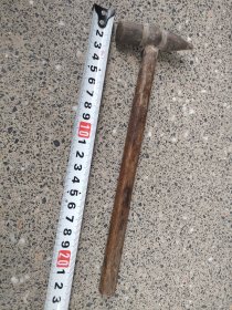 出一把银匠古董锤子，具有复古的韵味和历史感。锤头部分由金属制成，表面略显磨损，颜色呈深褐色，手柄部分为木制，结实耐用。此锤子适合收藏或作为道具使用，可增添家居的艺术氛围。