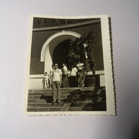 老照片–戴墨镜男子站在景区台阶上留影（身后游客和自行车清晰可见）