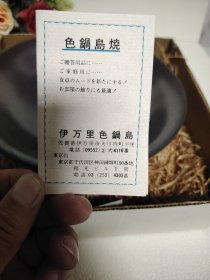 日本集体无形文化财持有者～伊万里色锅岛造。伊万里色锅岛窑元，铁砂釉大钵。原盒，陶历。直径22厘米，高6厘米。钵内有轻微运损磨痕，介意勿拍。老货无磕无冲。色锅岛是指用红、黄、绿三种颜色对青花瓷器加以釉上彩绘的锅岛烧，特征是高雅而沉静的色调以及细致的图案。 1976年，色锅岛被指定为日本的重要无形文化财（非物质文化遗产）即“人间国宝”。色锅岛纯色釉极其少见，此作品也代表着色锅岛在纯色釉领域也颇有建树。