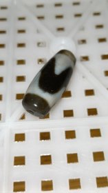 老台一达洛虎牙天珠，手工打磨，两端粗细不匀以及珠体都不正圆，包浆油润细腻温润，孔道压缩明显，皮下可见小密集风化纹，整体珠子还不错，有缘者恭请吧！
