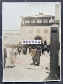 1939年4月 大东亚建设博览会的满洲馆前两名身穿旗袍的中国伪政府名贵少女引起众人瞩目 原版老照片一张（尺寸∶15.5*11.5cm。1939年4月在大阪甲子园举办了旨在宣扬侵華战争的“大东亚建设博览会”，并向当时的南京维新政府、华北临时政府两政府及满洲国致函征求治下名贵及特色手工参加该博览会。）