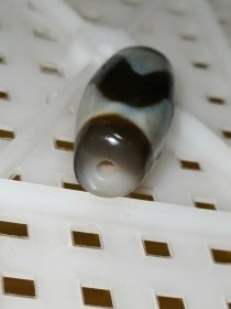 老台一达洛虎牙天珠，手工打磨，两端粗细不匀以及珠体都不正圆，包浆油润细腻温润，孔道压缩明显，皮下可见小密集风化纹，整体珠子还不错，有缘者恭请吧！