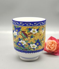 日本加贺屋茶杯，黄地蓝白花卉纹样，配红绿小鸟图案，釉色漂亮。杯身白胎，外壁施黄釉，内壁白釉，底部有加贺屋款。尺寸合适，做工精致，适合日常饮茶使用。口径7厘米，高8.5厘米。满58包邮偏远地区邮费自付。