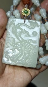 清代和田玉龙牌，手工立体浮雕，玉质细腻温润，洁白无瑕，皮壳包浆油润，雕刻四爪龙纹，规制十分考究，绝非普通百姓之物。链子本人后配，也是和田玉的葫芦形珠，南红三通，银鎏金镶嵌和田碧玉的背云，详细看图。